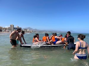 Jóvenes con aniridia jugando a juegos acuáticos en las playas de San Juan de Alicante